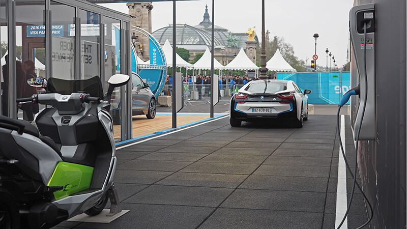 Mit einem Infostand auf den Pariser Champs-Élysées präsentiert BMW die ersten Modelle der Elektromobilität: BMW i3, BMWi8, BMW C. Die Fahrzeuge stehen auf schwarzem Eventboden von WARCO.
